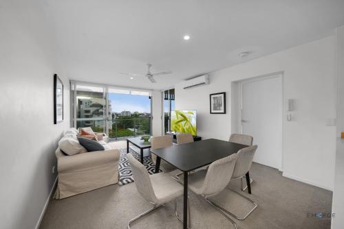 a living room with a table and chairs and a couch at Mowbray East Apartments in Brisbane