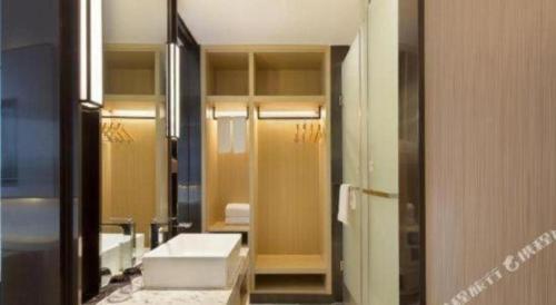 Un baño con lavabo y un espejo grande. en Echarm Hotel Changsha High-speed Railway Station, en Changsha