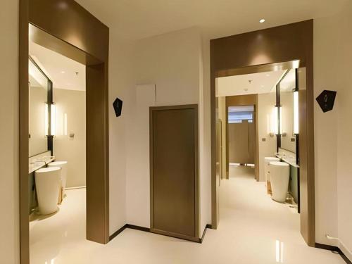 ein Badezimmer mit 2 WCs, 2 Waschbecken und Spiegeln in der Unterkunft City Comfort Inn Tai'an Taishan Tianwai Village Hongmen in Tai'an