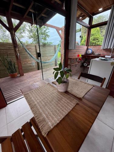 Zimmer mit einem Holztisch mit Topfpflanze in der Unterkunft Loft no centrinho do Rosa in Imbituba