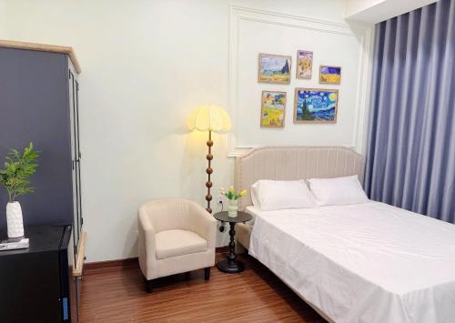 a bedroom with a bed and a chair and a lamp at Studio Apt OceanPark in Kon Rung (1)