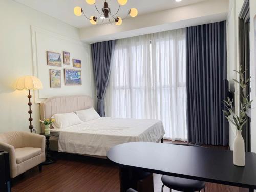 a hotel room with a bed and a table at Studio Apt OceanPark in Kon Rung (1)