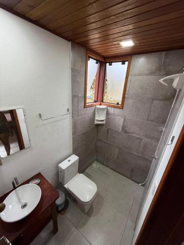 een kleine badkamer met toilet en wastafel bij Loft no centrinho do Rosa in Imbituba