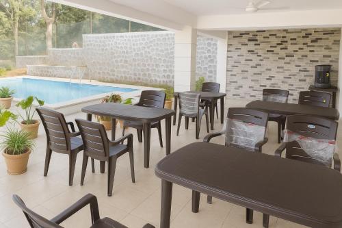 un ristorante con tavoli e sedie e una piscina di Hemgiri - Luxury 6BHK Private Pool Villa, Dam & Valley Views, Girivan Mulshi a Mulshi