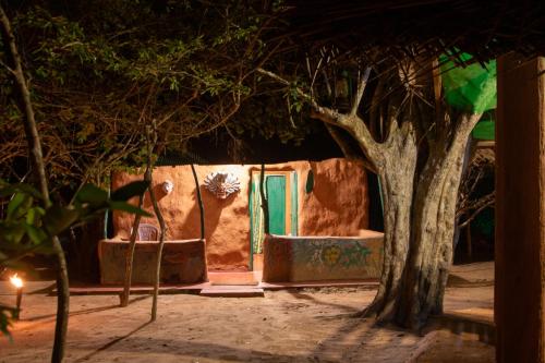 una casa con una puerta verde y un árbol en Yala Wild House, en Yala