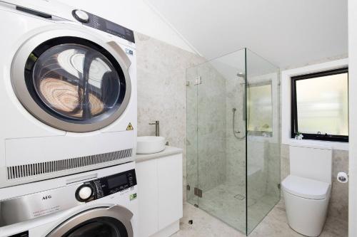 a washing machine in a bathroom with a shower at Solace by the Bay in Corlette