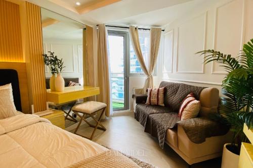 a bedroom with a couch and a bed and a window at Bali Videl - Studio with Queen Bed & Beach View in San Fernando