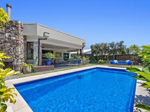 a swimming pool in front of a house at The Doggy Beach House - with Pool in Pottsville in Pottsville