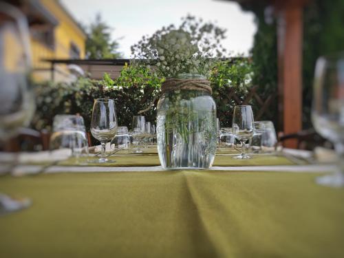 a table with wine glasses and a jar on it at Masseria Monte Pizzi in Carovilli