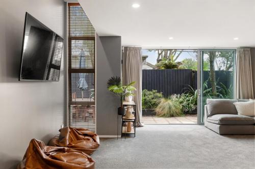 a living room with a couch and a television at The City Retreat in Christchurch
