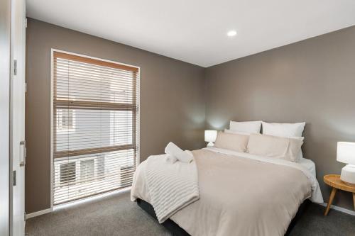 a bedroom with a large bed and a window at The City Retreat in Christchurch