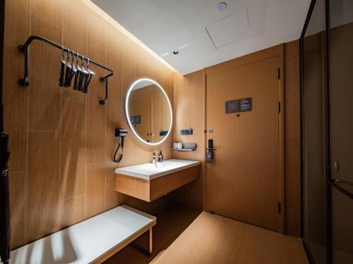 une salle de bains avec un lavabo et un miroir dans l'établissement JI Hotel Chengdu Wenjiang University Town, à Chengdu
