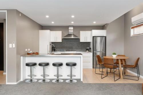 a kitchen with a counter and a table with stools at The City Retreat in Christchurch