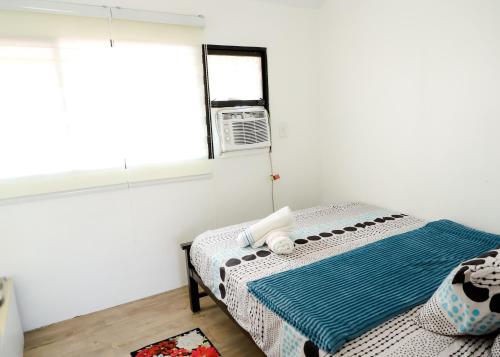 a white room with a bed with a window at Clark Stays Yellow in Iba