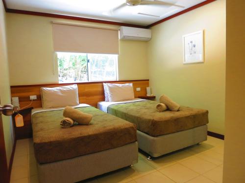 Un pat sau paturi într-o cameră la The Cocos Padang Lodge