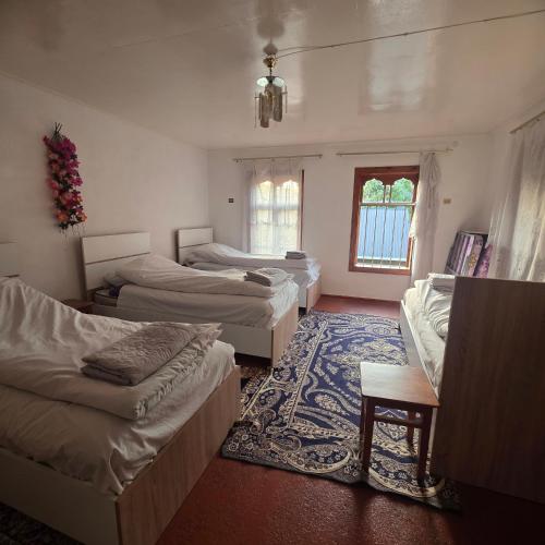 a room with three beds and a rug at Sim Guesthouse in Sım