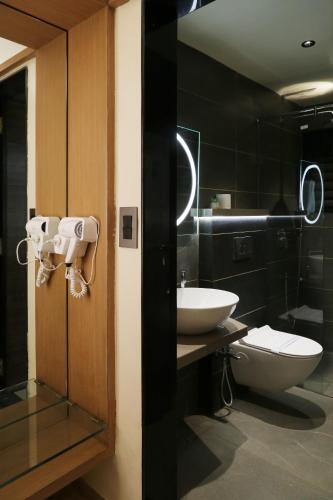 ein Badezimmer mit Toilette und Waschbecken in der Unterkunft Hotel The Leaf in Aurangabad