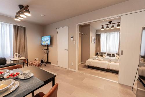 a bedroom and living room with a bed and a table at Mi-HOTEL Kitashinjuku in Tokyo