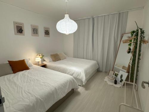 a bedroom with two beds and a pendant light at Won-Stay in Samgong