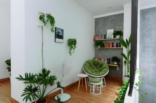 a room with a green chair and some plants at Nha Trong Pho - Green House in Buôn Ðũng