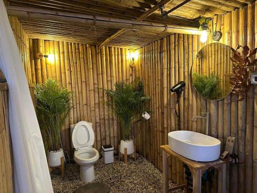 een houten badkamer met een toilet en een wastafel bij แล้วแต่เพื่อนวิลล่า in Ban Huai Khai