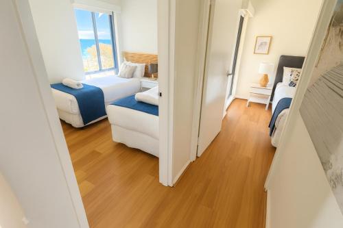 a small room with two beds and a window at Sunset On Esplanade in Perth