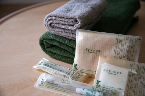 a table with a pile of towels and a book at Family Stay & Relaxation -Tokyo East- in Tokyo