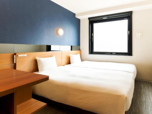 a bedroom with a bed and a desk and a window at Rakuten STAY URBAN Kyoto Shijo Omiya in Kyoto