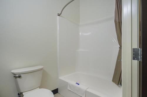a white bathroom with a toilet and a shower at Motel 6-South Bend, IN - Mishawaka in South Bend