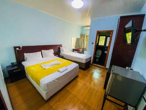 Premium City Guesthouse في غابورون: غرفة نوم بسرير كبير مع بطانية صفراء