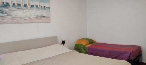 Una habitación con dos camas y un cuadro en la pared. en La casa di Gergy, en Borgomanero