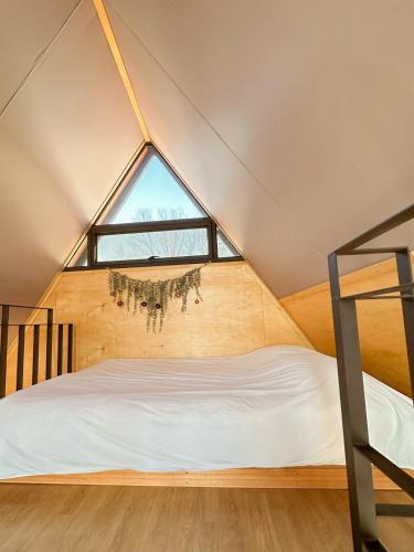 a bed in a room with a large window at 가평 스페인마을 풀램핑 Spanish Village Poolamping in Hwarangp'o