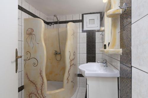ein kleines Badezimmer mit Waschbecken und Dusche in der Unterkunft Apollon Rooms in Pollonia