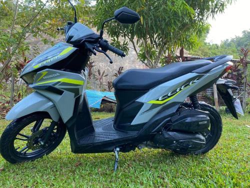 a motorcycle parked in the grass in a yard at Tiwi's Travellers Inn in Puerto Princesa City