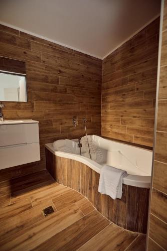 a bath tub in a bathroom with wooden walls at אריה במדבר - וילה מושלמת עם בריכה פרטית מחוממת באילת in Eilat
