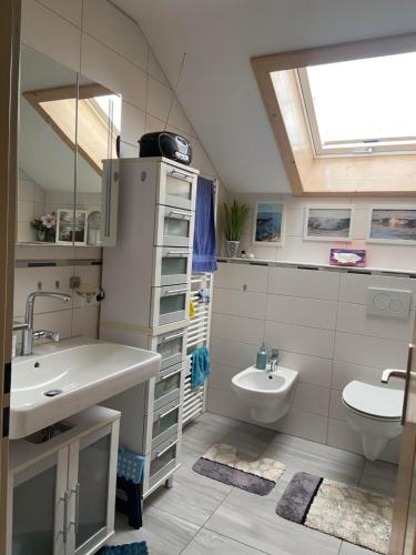 a bathroom with a sink and a toilet and a mirror at Ferienwohnung Falkensteinblick in Pfronten