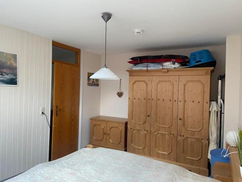 a bedroom with a bed and a wooden dresser at Ferienwohnung Falkensteinblick in Pfronten