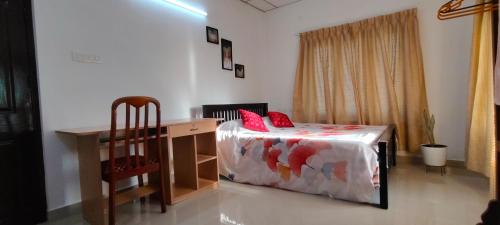 a bedroom with a bed and a desk and a chair at Anaaya Riverside Nest in Jāmb