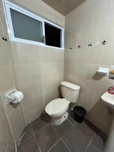 a bathroom with a toilet and a sink at Posada Oasis in Cuetzalán del Progreso