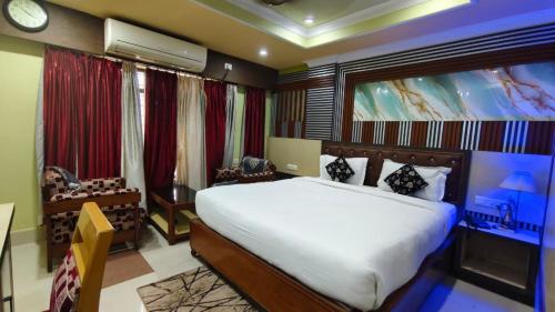 a bedroom with a bed and a large painting on the wall at Hotel Gokul Plaza Near Railway Station Bhubaneswar in Bhubaneshwar