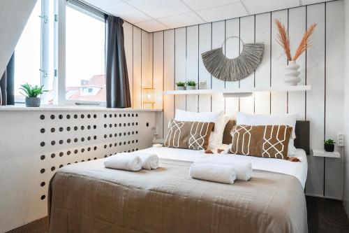 Budget Private Room Near Zoutelande Beach في زوتلاند: غرفة نوم بها سرير كبير عليه منشفتين