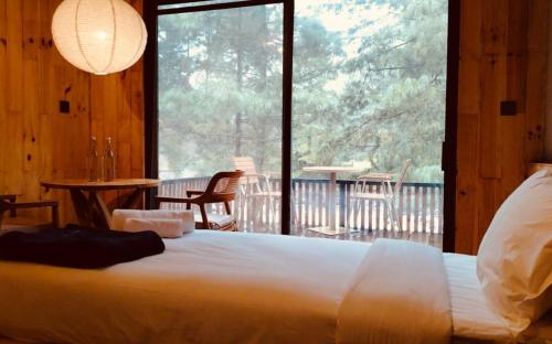 a bedroom with a bed and a large window at The Himalayan Phakding in Phakding