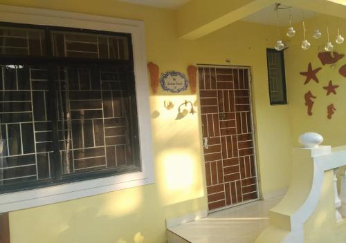 Villa Neesham Grande في بيناوليم: غرفة بها نافذة وساعة على الحائط