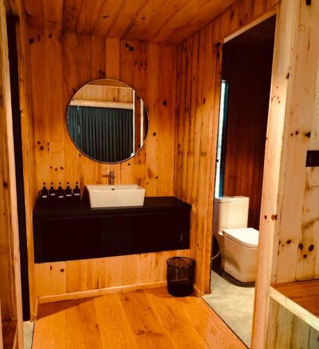 a bathroom with a sink and a mirror and a toilet at The Himalayan Phakding in Phakding