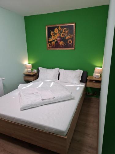 una camera da letto con una parete verde e un letto di Popas La Vintu 