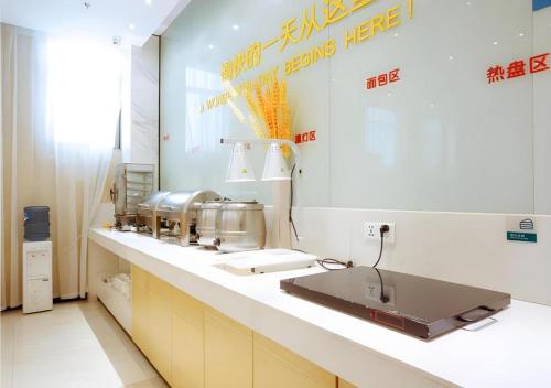 a kitchen with a counter with a sink in it at City Comfort Inn Xianning South Station Wanda in Wenquanzhen