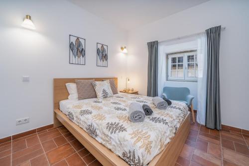een slaapkamer met een bed en een blauwe stoel bij Apartamento Karolvaz V in Silves