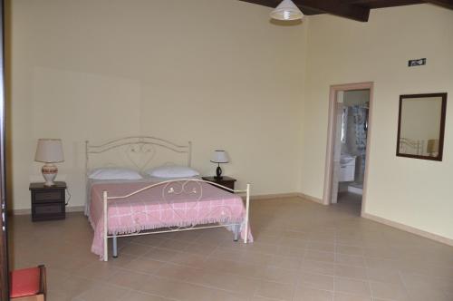 een slaapkamer met een roze bed en een spiegel bij Artemis in Mirto Crosia