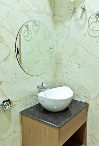a bathroom with a white sink and a mirror at Kumar Green Resort in Guwahati