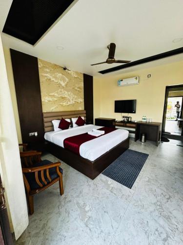 a bedroom with a large bed and a flat screen tv at Kumar Green Resort in Guwahati